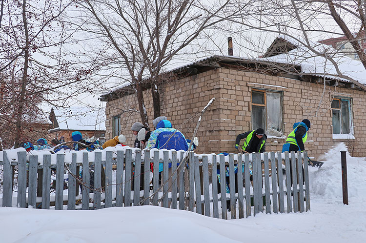 Kazakistan’da genç gönüllüler, kimsesiz yaşlıların evlerinin etrafındaki karları temizliyor