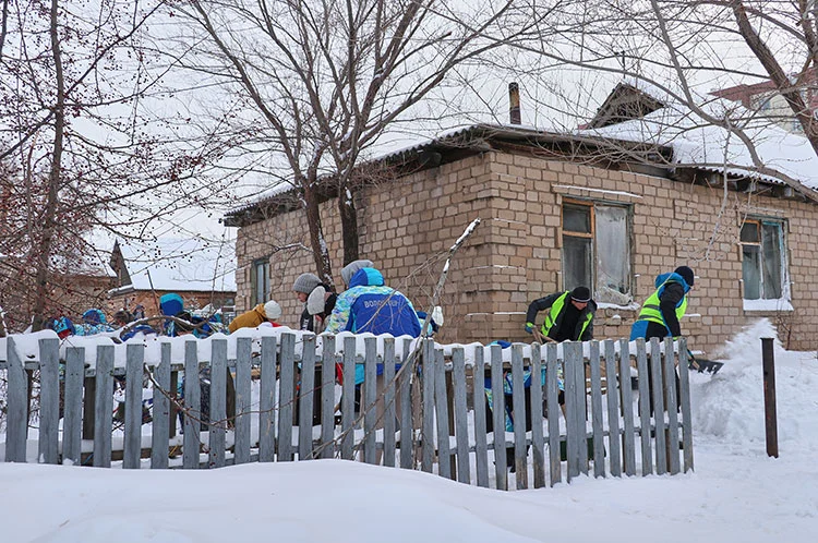 Kazakistan’da genç gönüllüler, kimsesiz yaşlıların evlerinin etrafındaki karları temizliyor