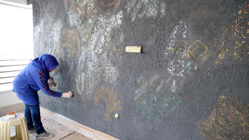 Tuvale dönüştürdüğü ev ve iş yerlerinin duvarlarını renklendiriyor