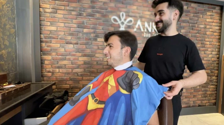 Müşterilerini çizgi film karakterli önlüklerle tıraş ediyor