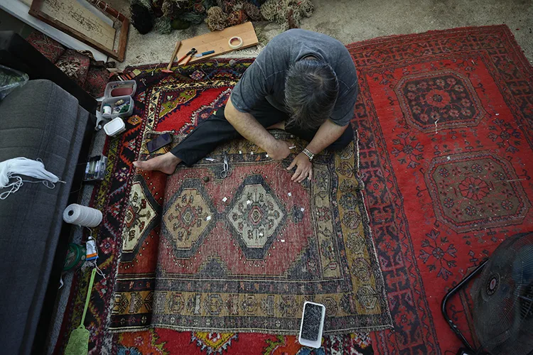 Halıları cerrah titizliğiyle onarıyor
