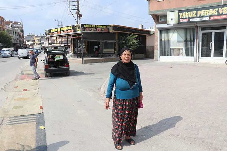 Adana’da tozdan rahatsız olan kadın yoldaki çukurları halıyla kapattı