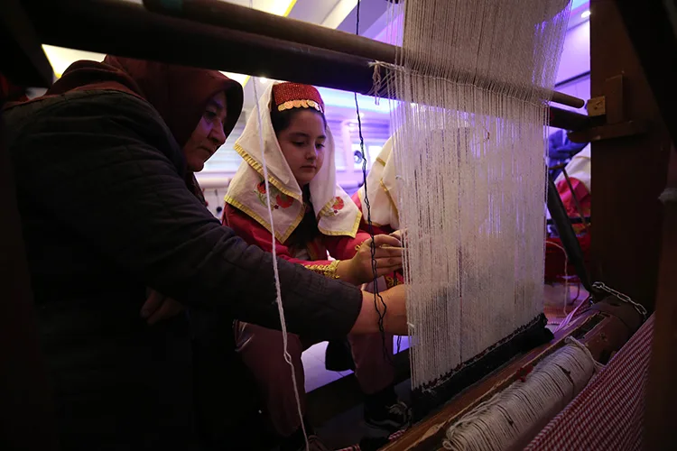 İlkokul öğrencileri, coğrafi işaretli Yağcıbedir halısını dokumayı öğrenmek için tezgah başında